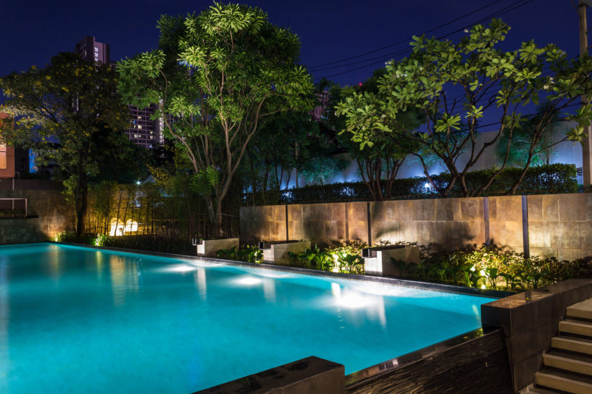 pool-lights Swimming pool with trees and lights at night.